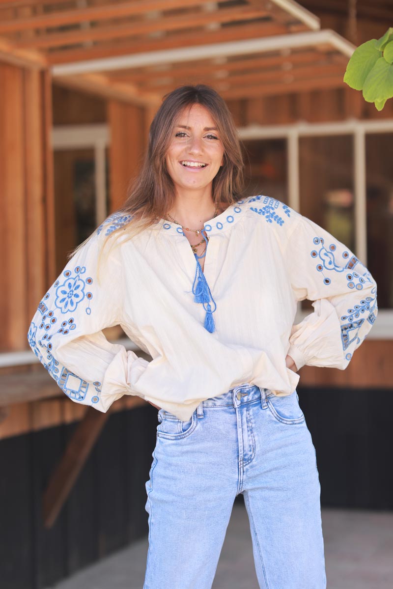 Blouse beige en coton broderie ajourée bleu et pompons