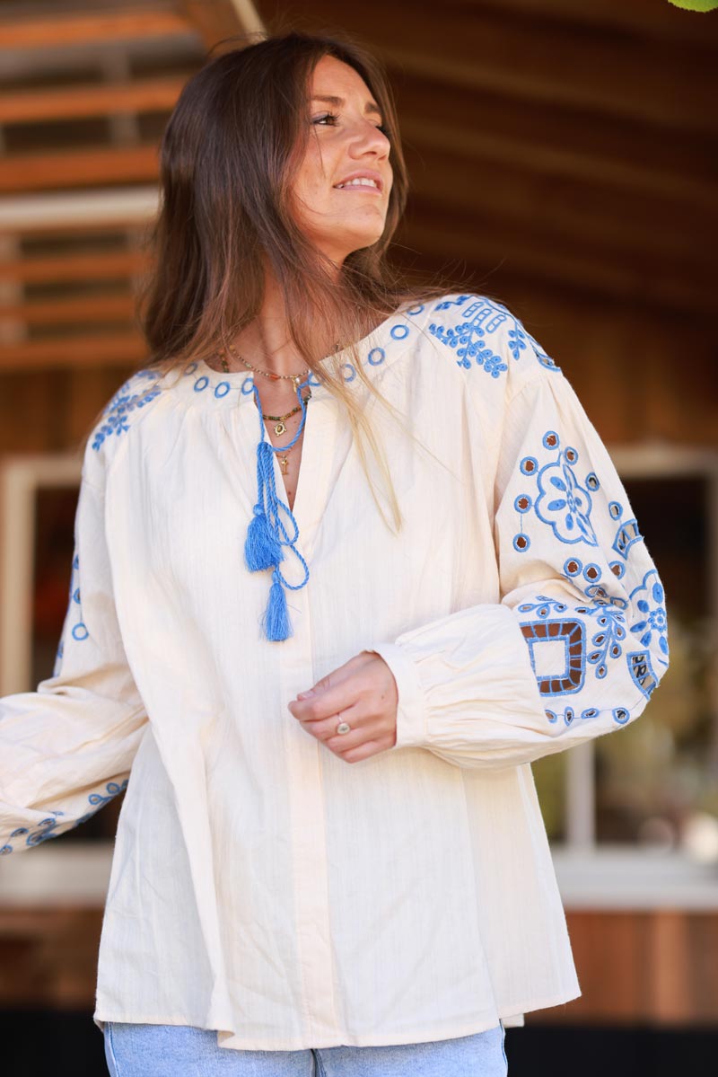 Blouse beige en coton broderie ajourée bleu et pompons