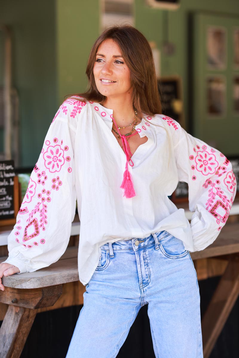 Blouse blanche en coton broderie ajourée fuchsia et pompons