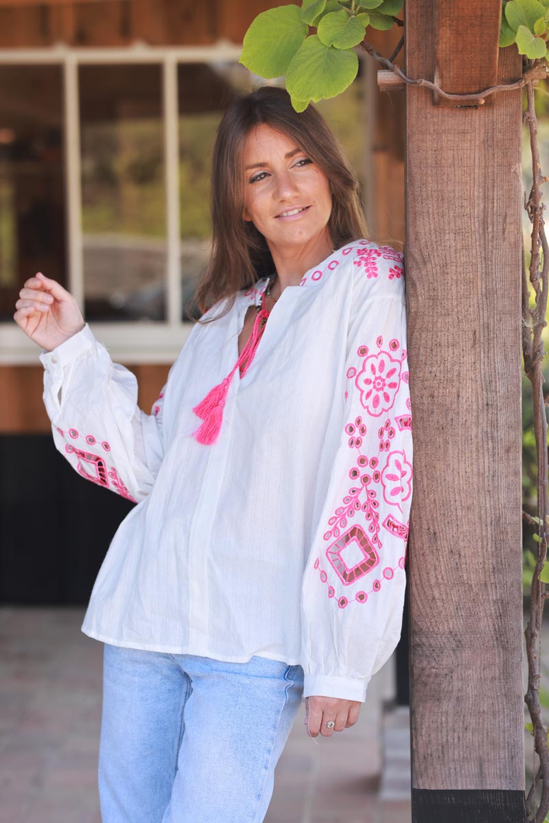 Blouse blanche en coton broderie ajourée fuchsia et pompons