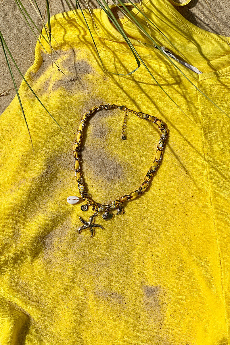 Collar en gran malla dorada de tela amarilla retorcida con colgantes de concha de estrella de mar