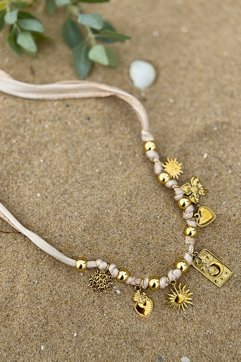 Collier ruban beige et pendentifs dorés trèfle soleil cœur et lune