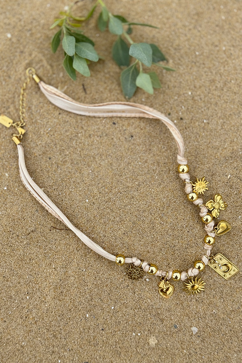 Collier ruban beige et pendentifs dorés trèfle soleil cœur et lune