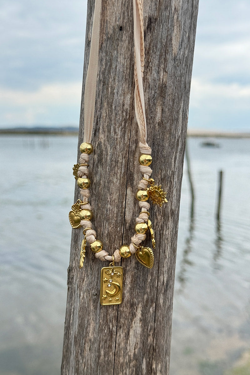 Collier ruban beige et pendentifs dorés trèfle soleil cœur et lune