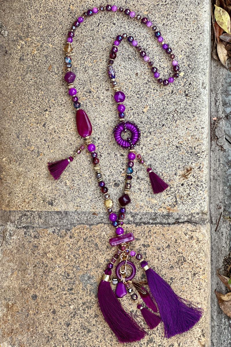 Collier sautoir en perles nuances de violet avec pompons et plumes