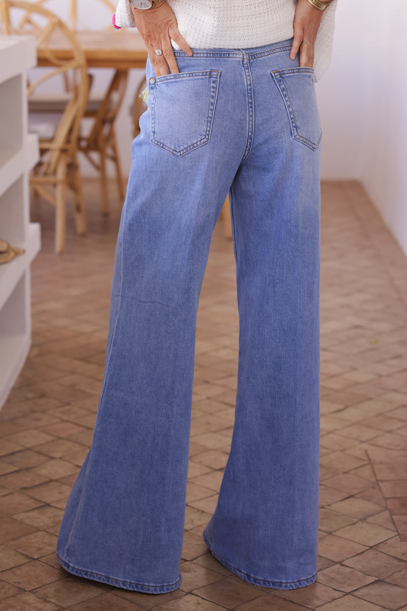 Light washed denim flare jeans with woven colourful and gold belt