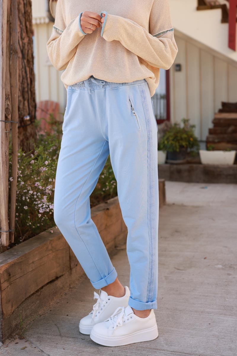 Light blue cotton jogging bottoms with embroidered cheveron outseams