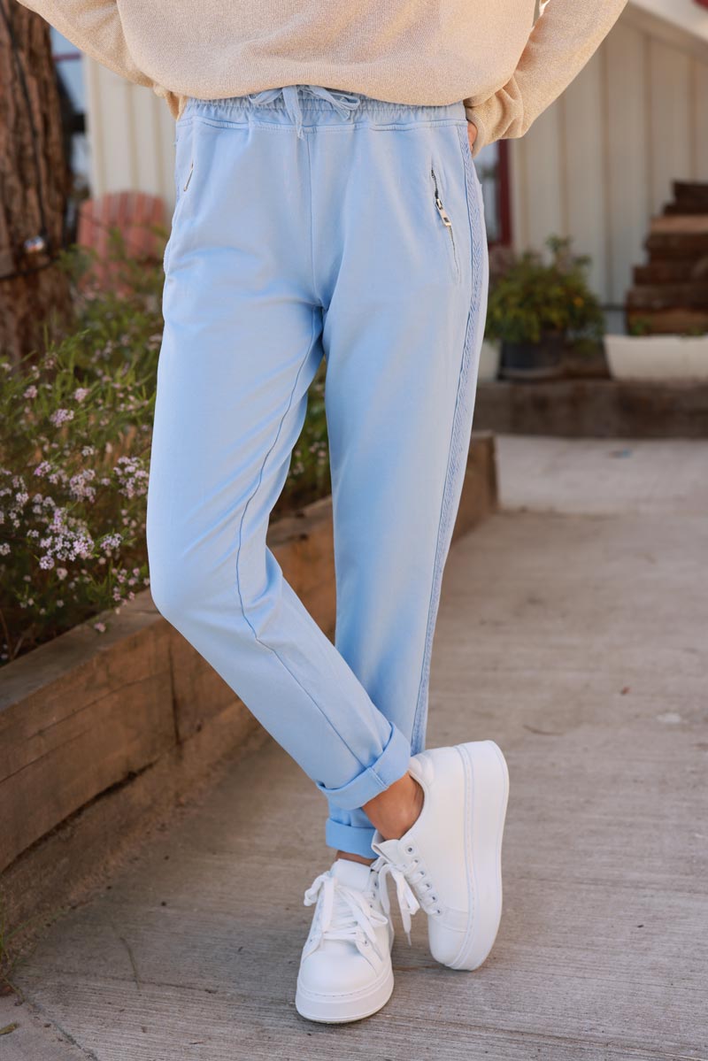 Light blue cotton jogging bottoms with embroidered cheveron outseams