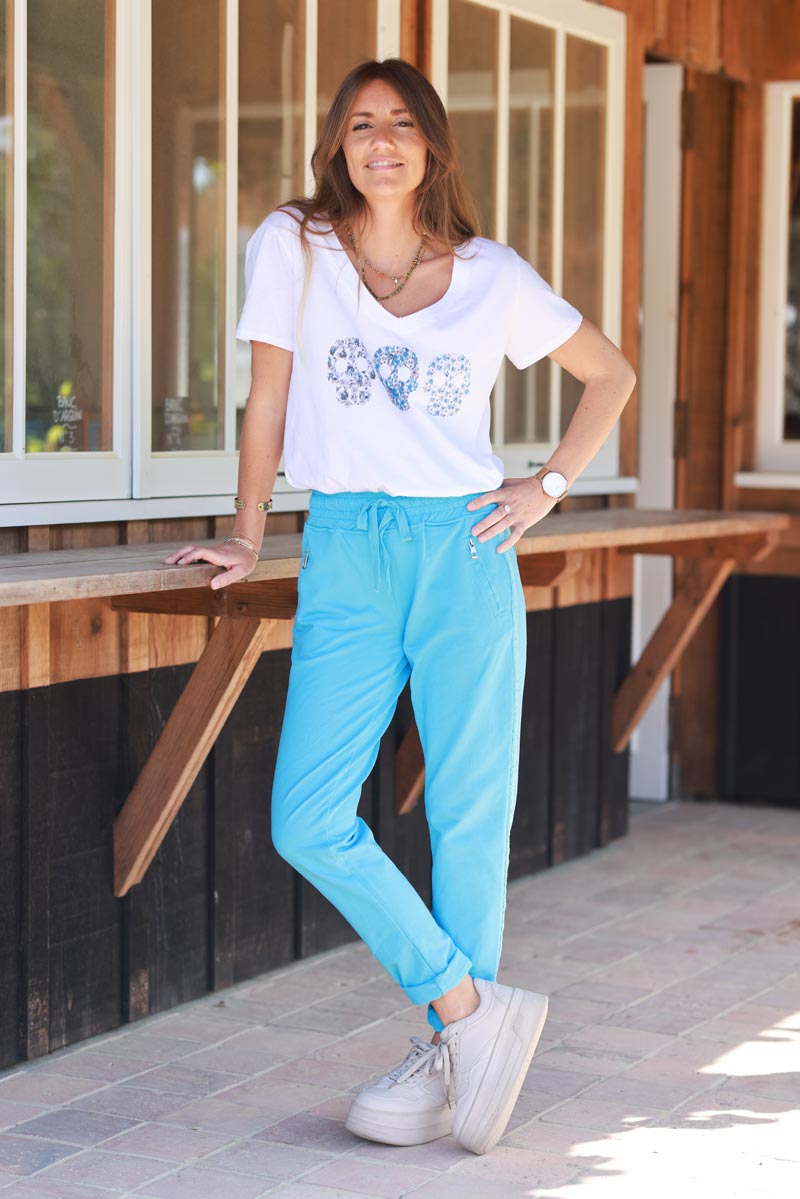 Pantalón de jogging de algodón azul con cinturilla elástica y bolsillos con cremallera con ribete de bordado de espiga