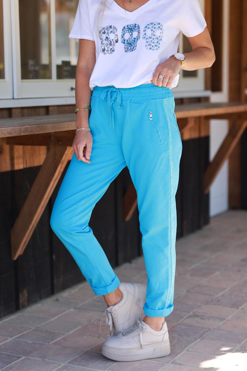 Pantalón de jogging de algodón azul con cinturilla elástica y bolsillos con cremallera con ribete de bordado de espiga