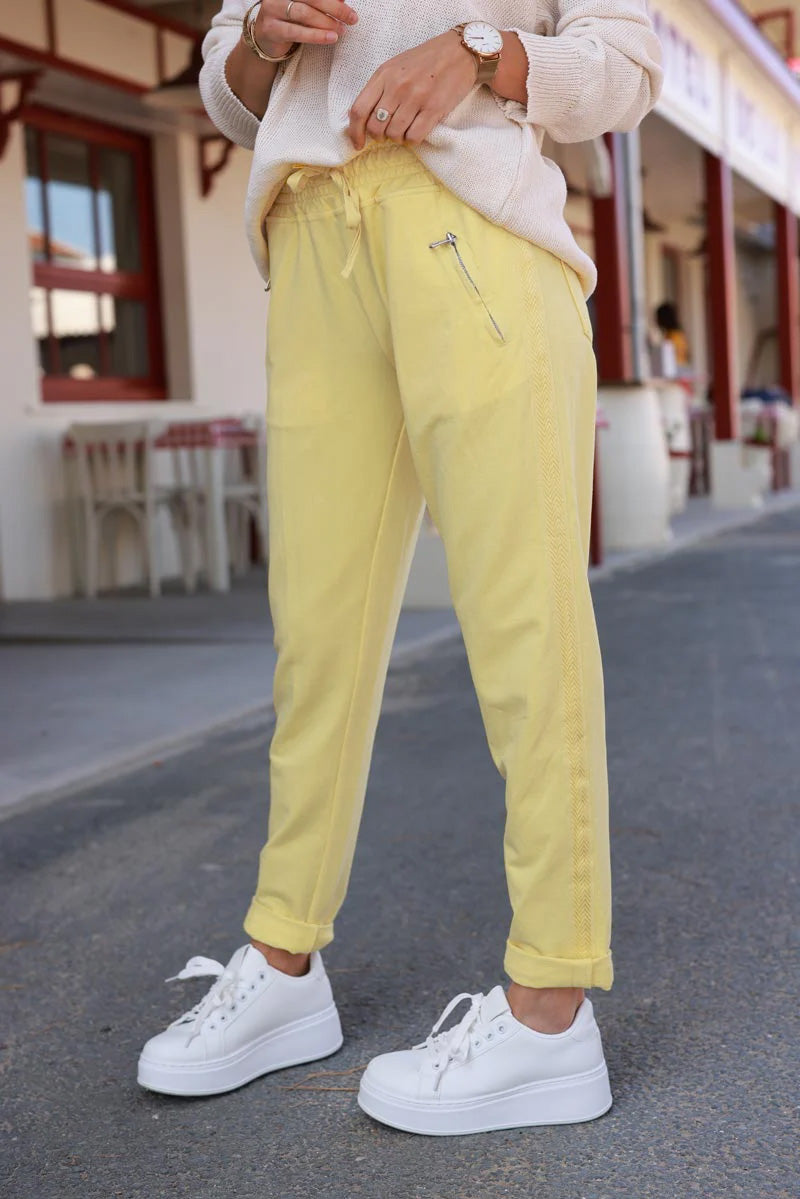 Jogging jaune pâle en coton à ceinture élastique, poches zippées et liseré broderie chevrons