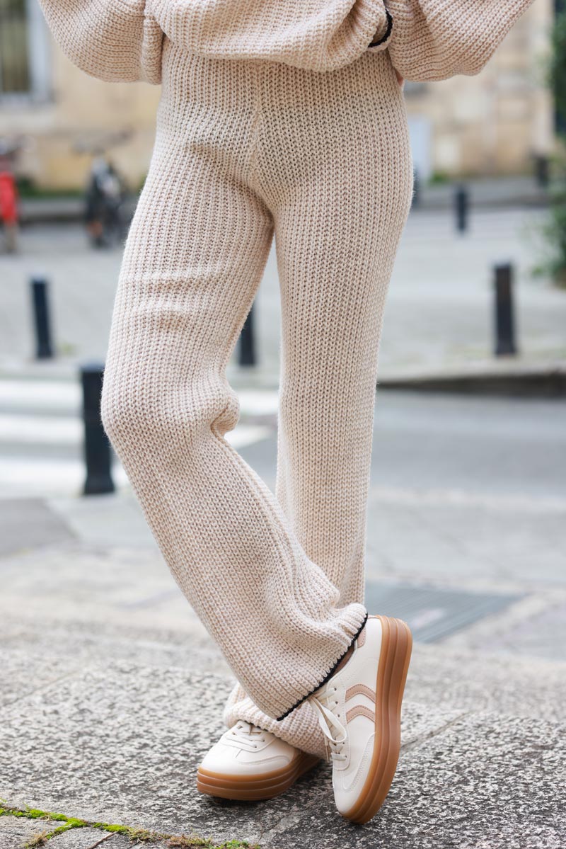 Pantalon en maille beige style crochet coupe évasée détail liseré noir