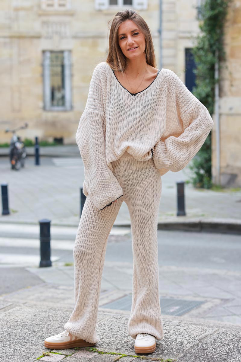 Pantalon en maille beige style crochet coupe évasée détail liseré noir
