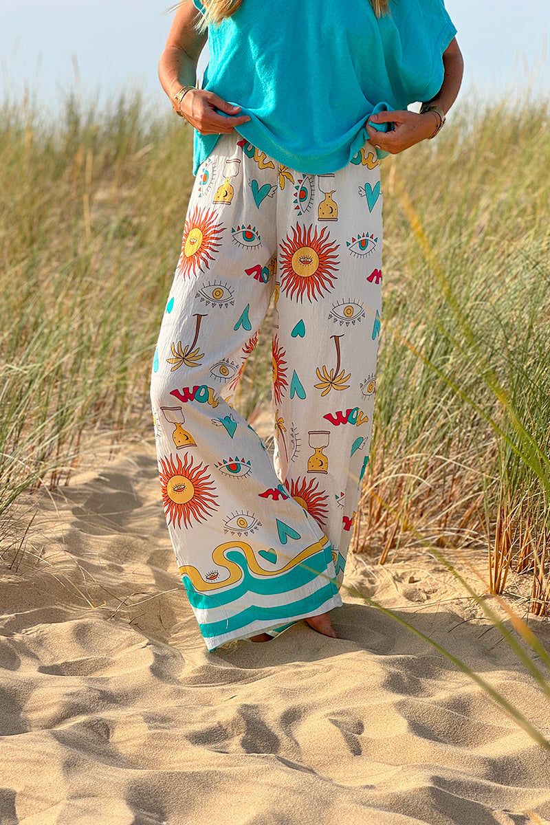 Pantalon fluide écru symboles soleil œil et cœurs colorés turquoise