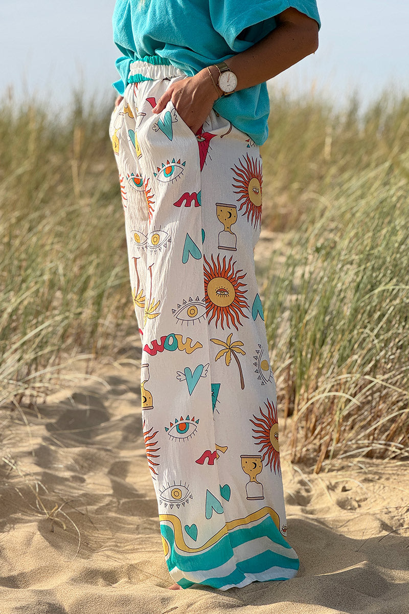 Pantalon fluide écru symboles soleil œil et cœurs colorés turquoise