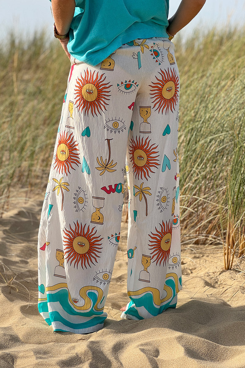 Pantalon fluide écru symboles soleil œil et cœurs colorés turquoise