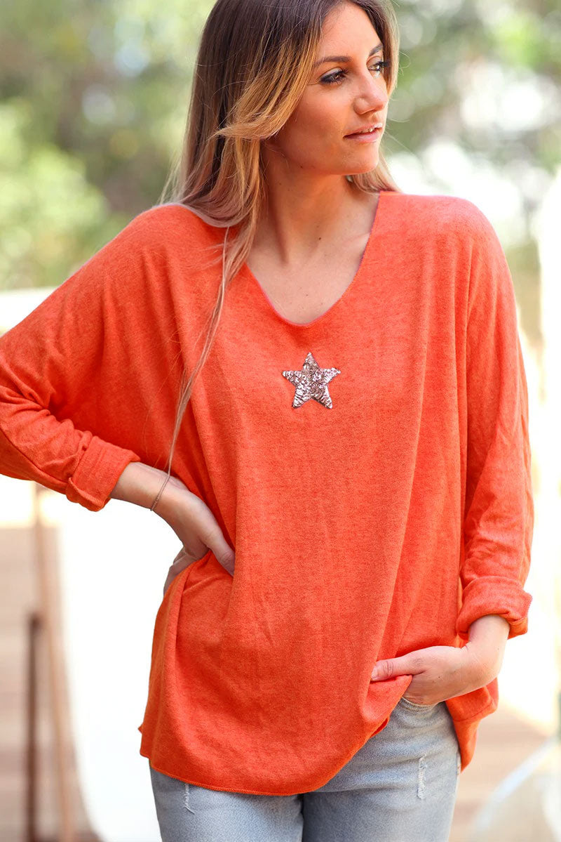 Jersey naranja con cuello de pico y pequeña estrella de lentejuelas