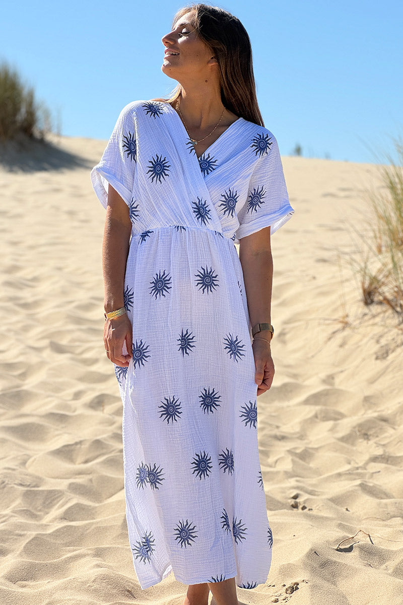Vestido largo de gasa de algodón blanco con estampados de soles en denim azul, escote en pico y espalda abierta.