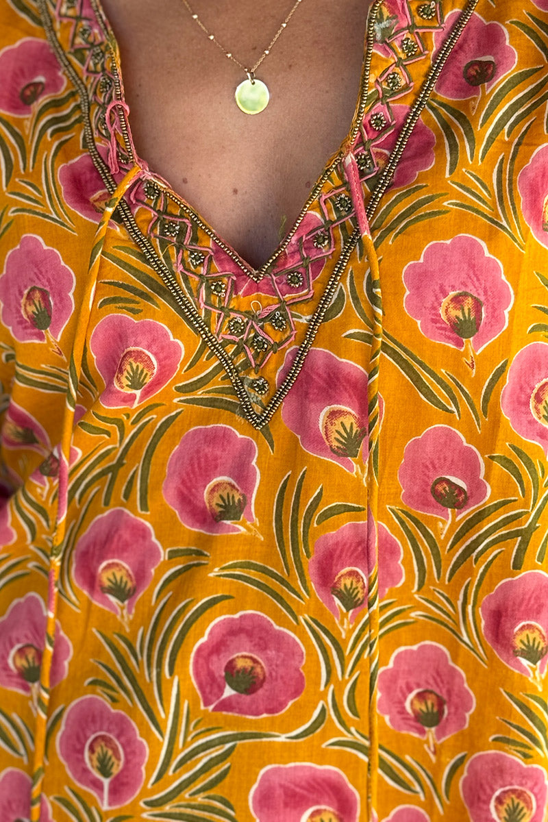 Robe longue orange en coton imprimé fleurs roses col perles et pompons