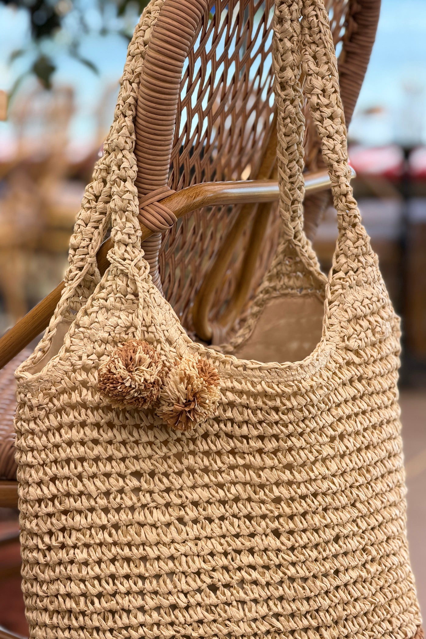 Sac effet paille tressée bicolore naturel et camel avec pompons
