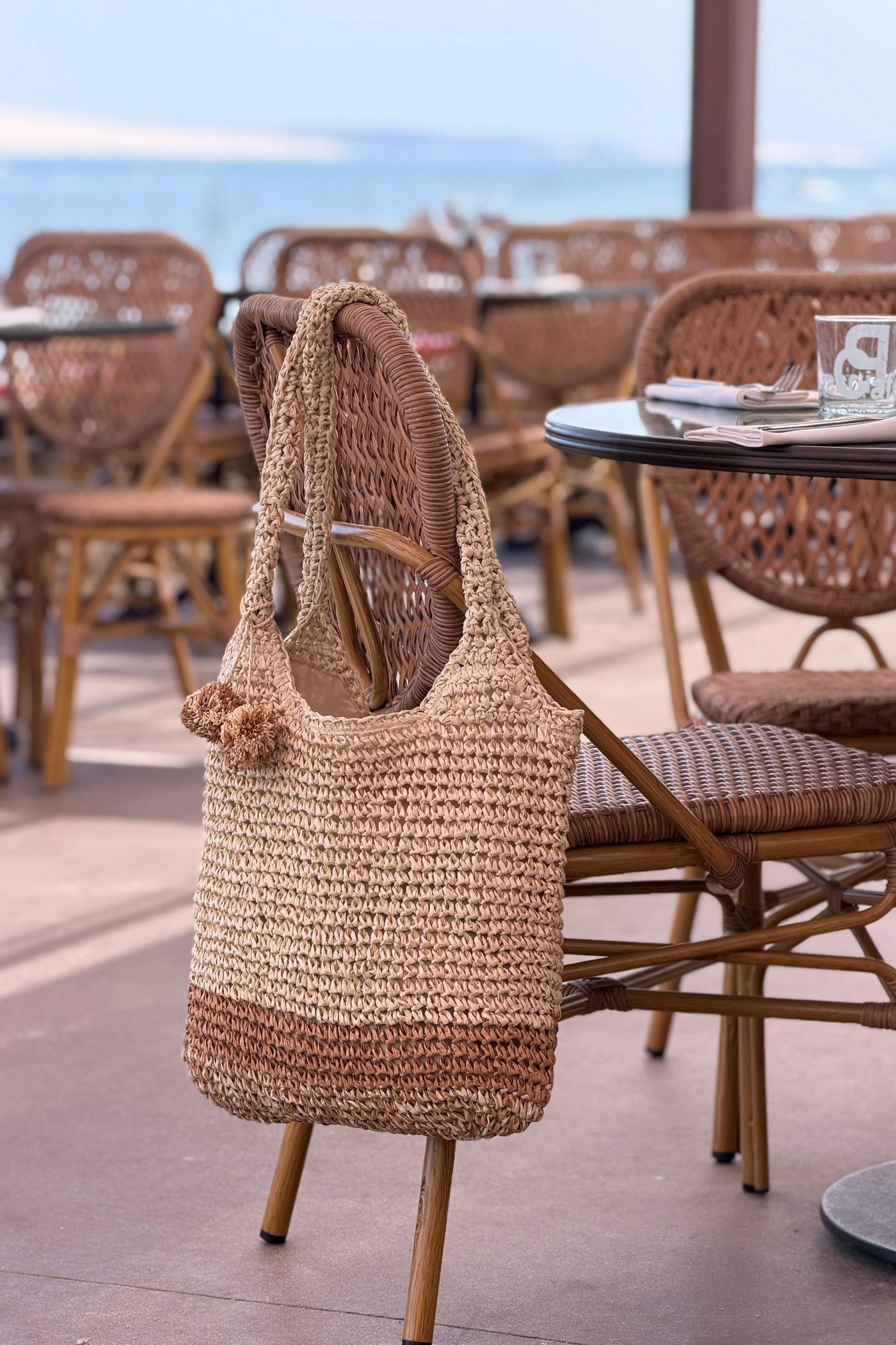 Sac effet paille tressée bicolore naturel et camel avec pompons