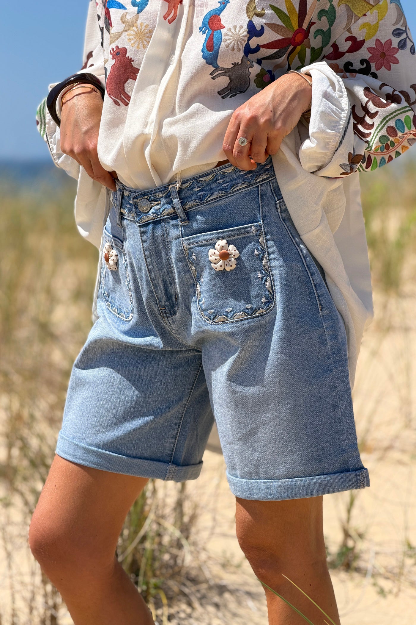 Short long en jean délavé poches plaquées broderie et fleurs en tissu