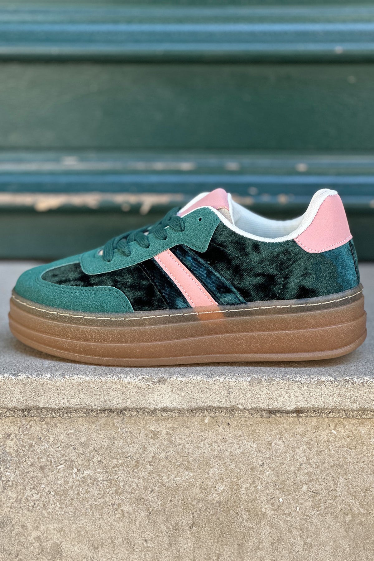 Zapatillas de tenis de plataforma de terciopelo verde con rayas y tacón rosa.