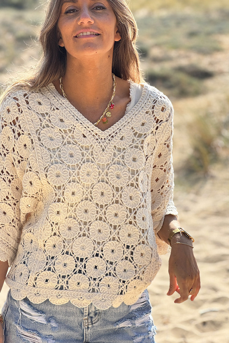 Top de crochet beige con rosetas y mangas murciélago y escote en pico