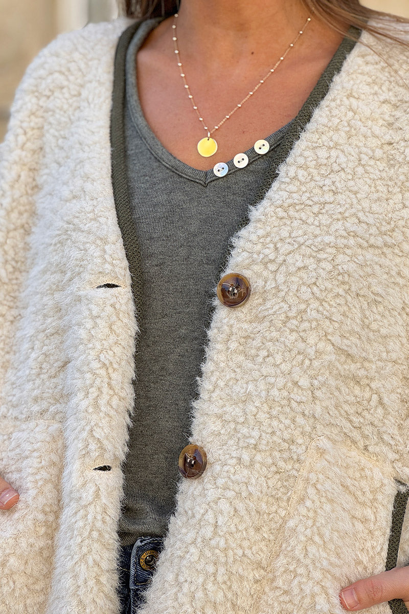 Veste sans manches en moumoute beige détail liseré kaki boutons écaille marron