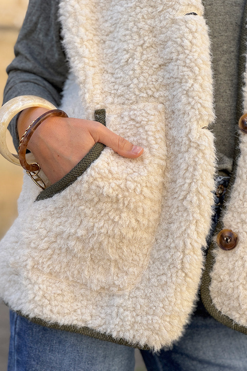 Veste sans manches en moumoute beige détail liseré kaki boutons écaille marron