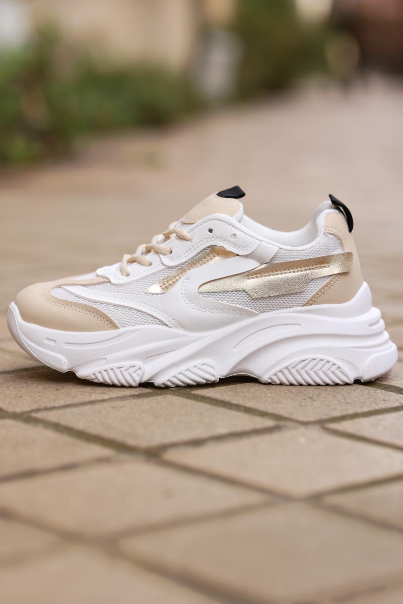 Zapatillas deportivas beige con aplicación dorada.