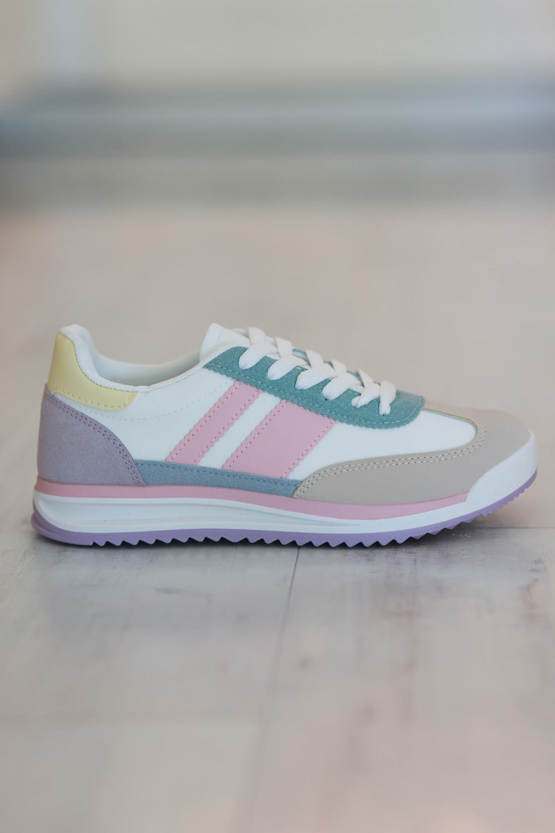 Zapatillas blancas con aplicaciones en rosa pastel, verde agua y amarillo.