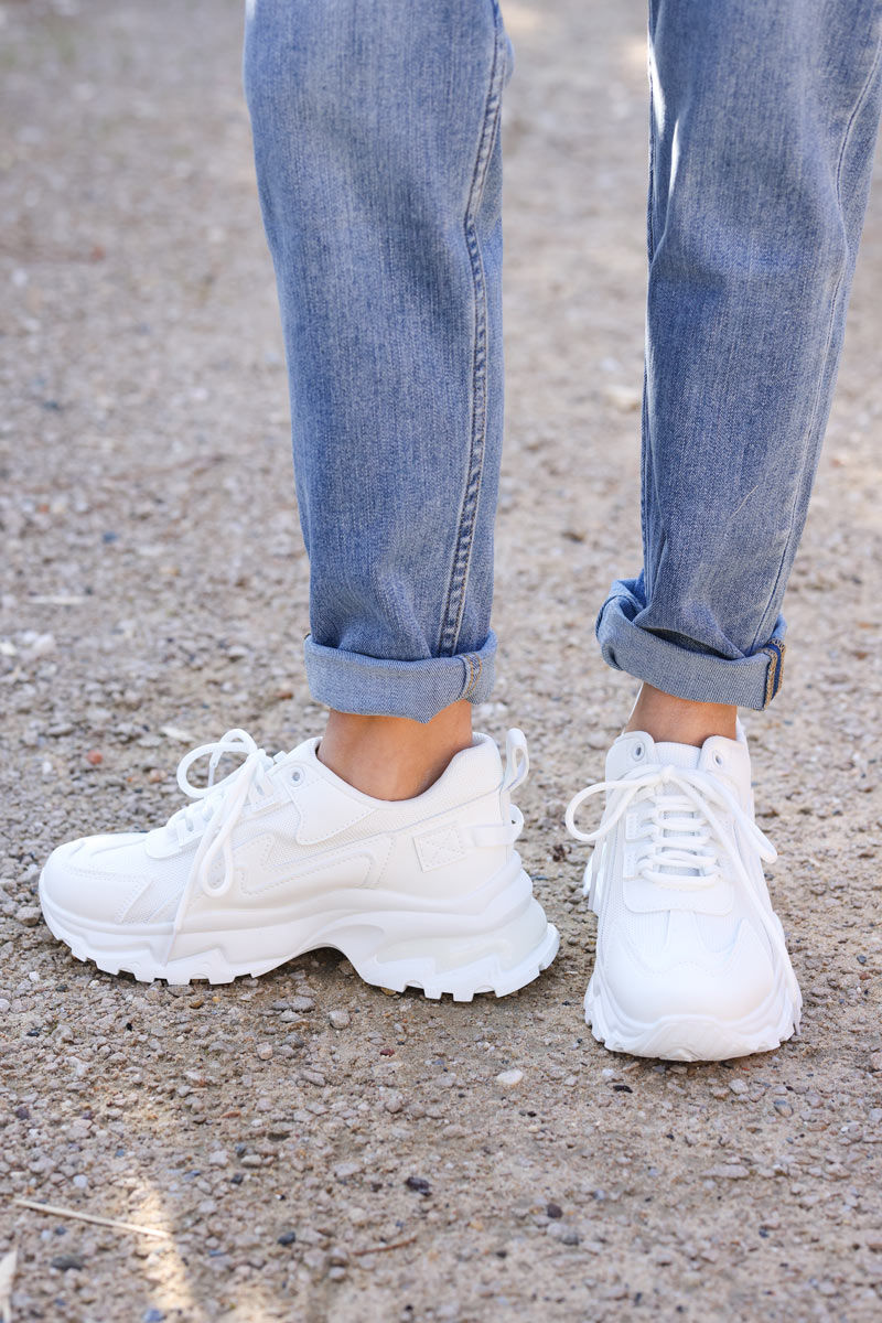 Zapatillas blancas con suela gruesa.