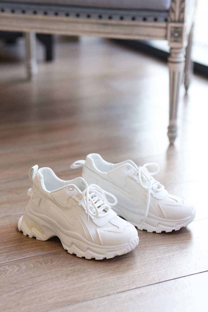 Zapatillas blancas con suela gruesa.