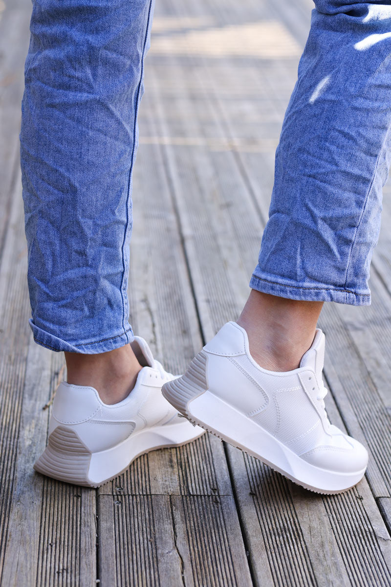 Zapatillas deportivas blancas con suela gruesa.