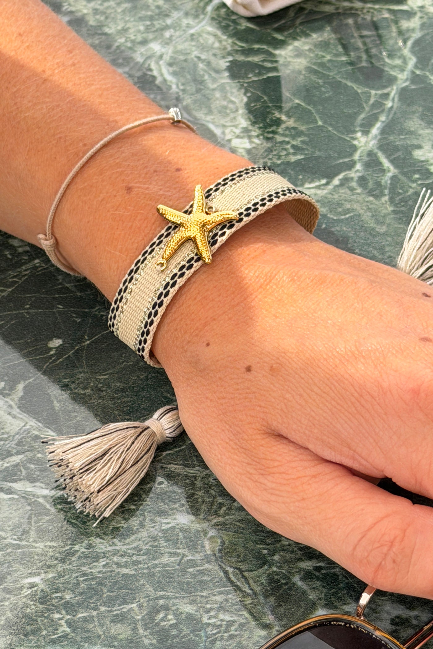 Bracelet en tissu beige réglable avec pompons breloque Etoile de mer dorée