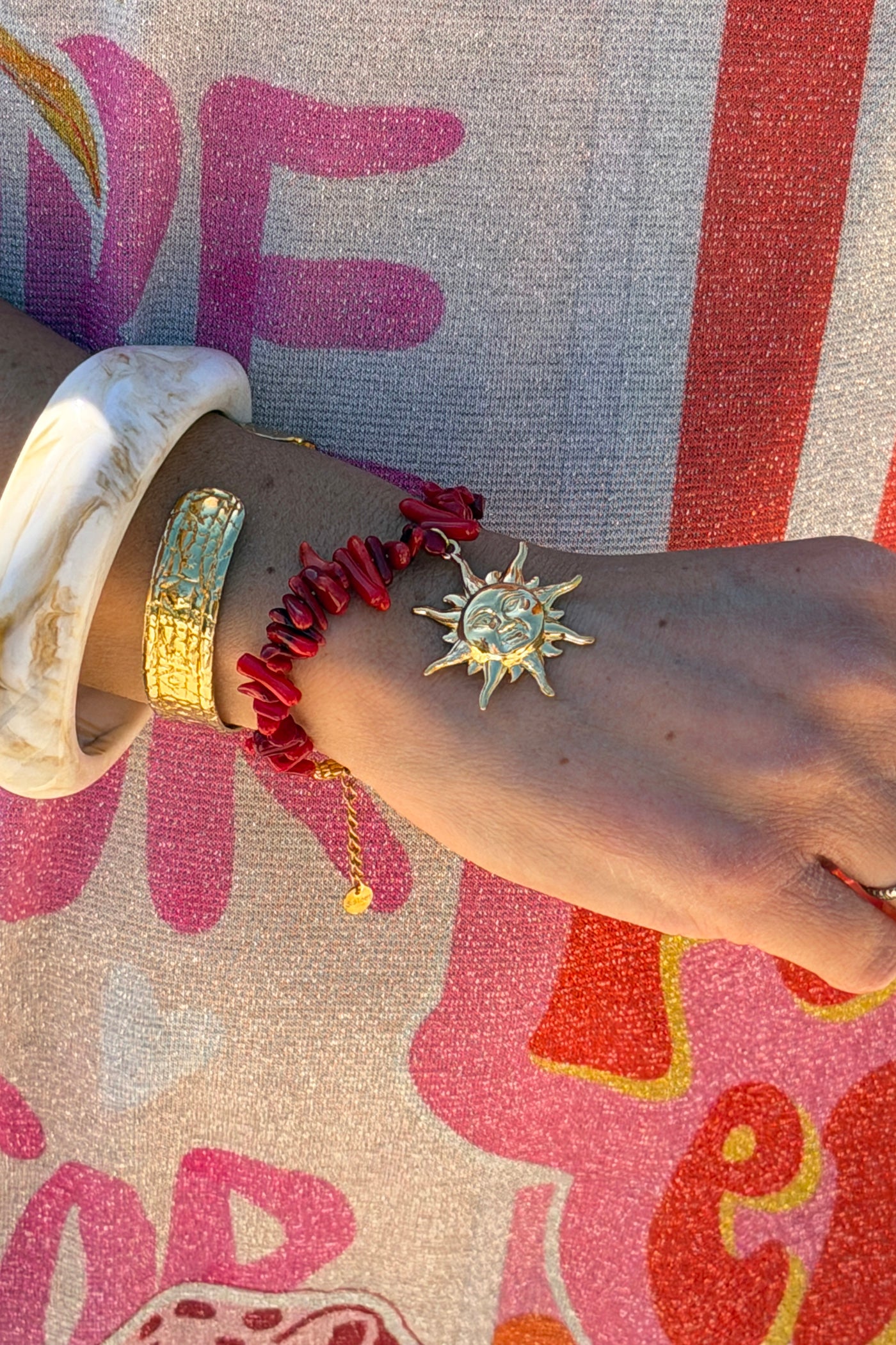 Bracelet petite pierres irrégulières effet corail pendentif soleil doré