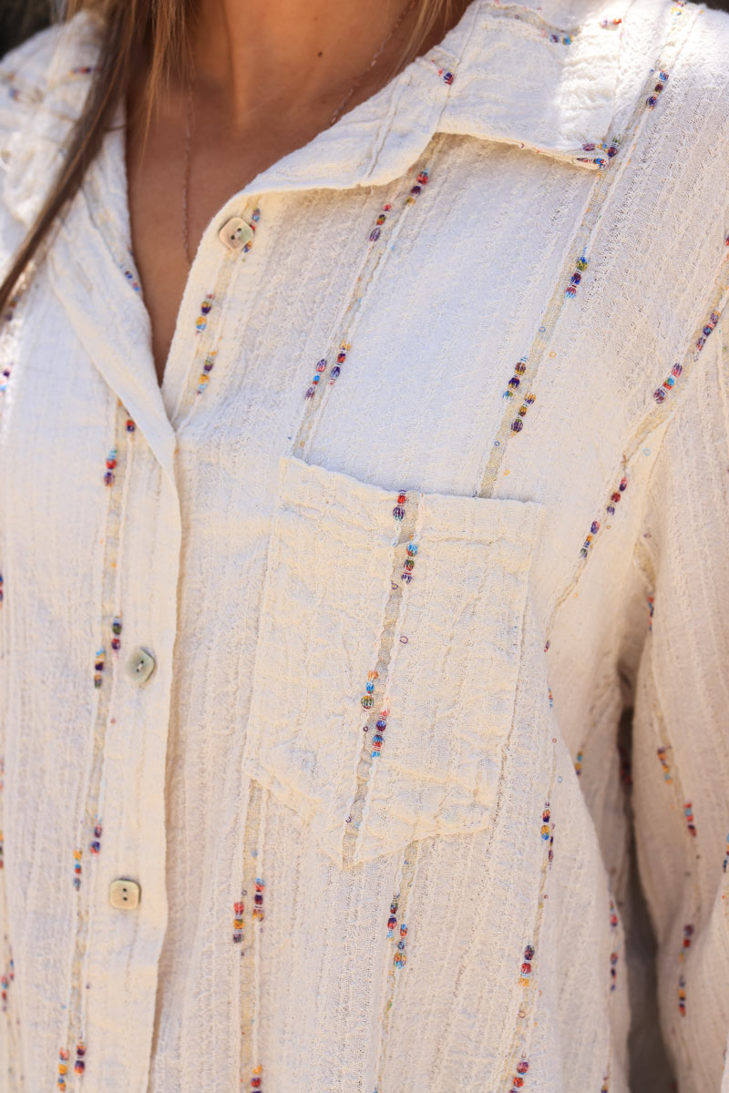 Chemise beige avec une poche liseré fils colorés et dorés
