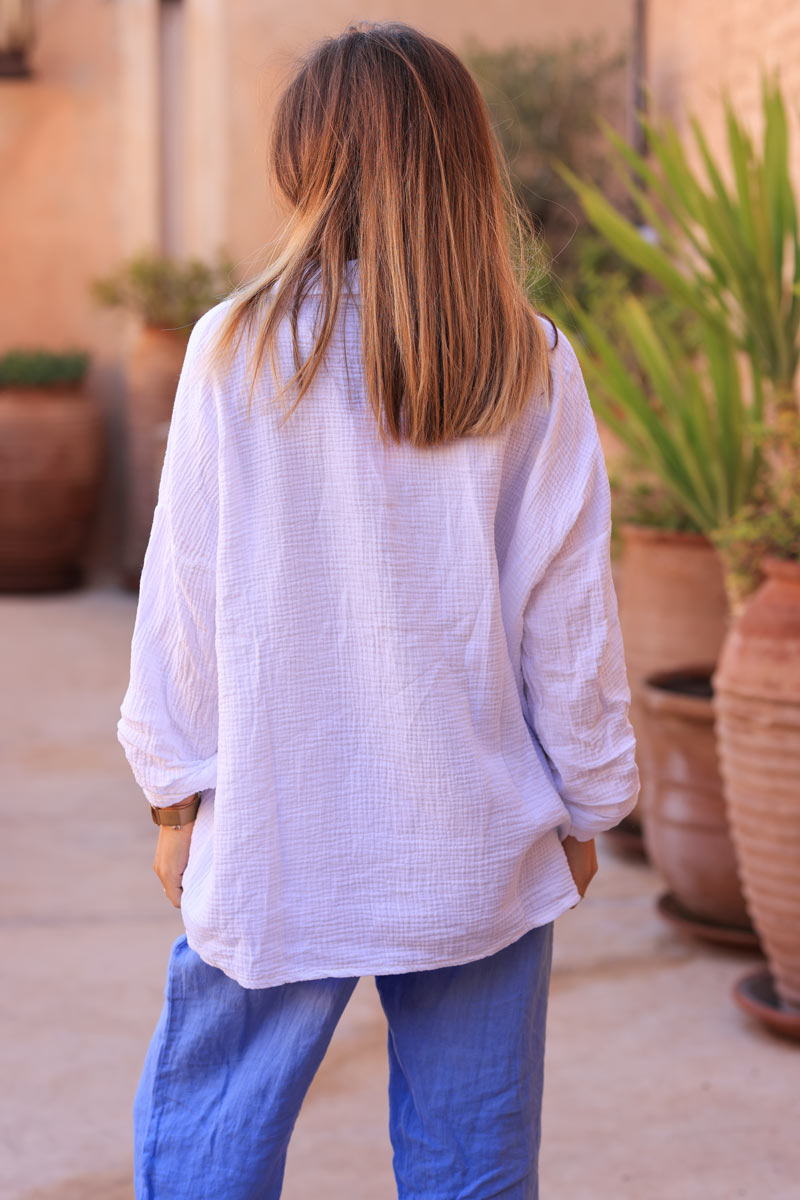Camisa de gasa de algodón blanca con bordado de flores azules.
