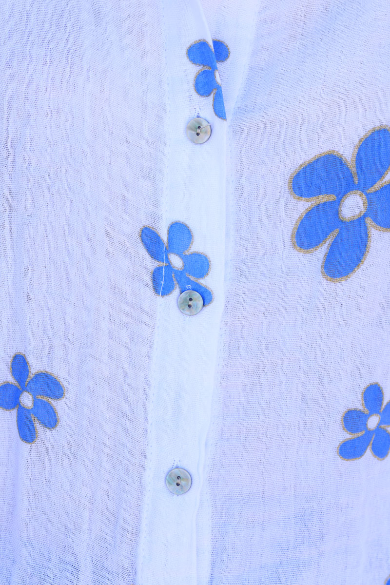 Camisa de gasa de algodón blanca con estampado de flores azules y ribete dorado.