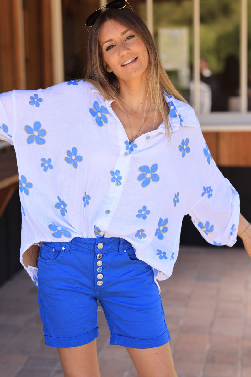 Camisa de gasa de algodón blanca con estampado de flores azules y ribete dorado.