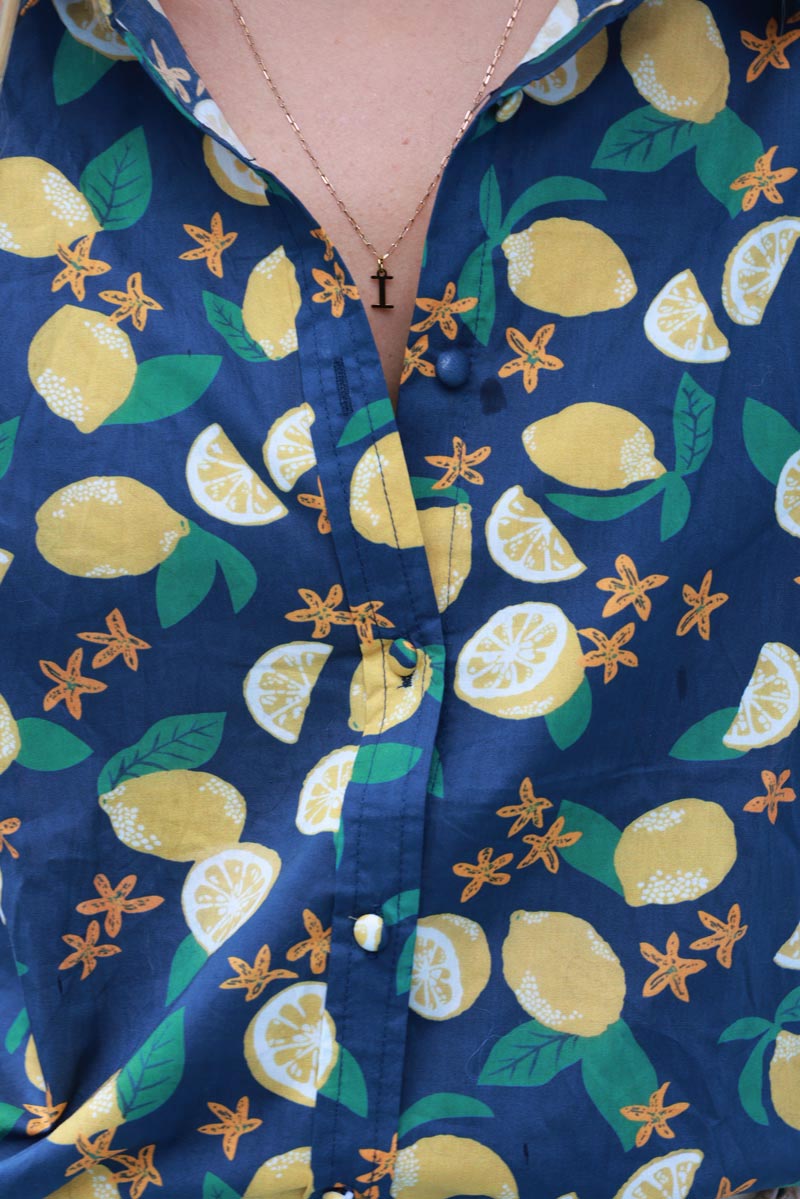 Camisa de algodón azul marino con estampado de limones y flores.