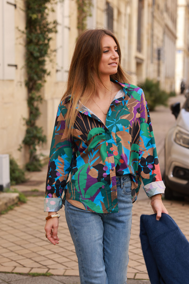 Camisa de algodón azul con estampado de palmeras y hojas verdes y marrones.