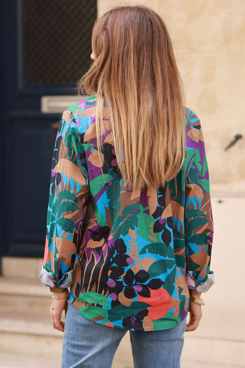 Camisa de algodón azul con estampado de palmeras y hojas verdes y marrones.