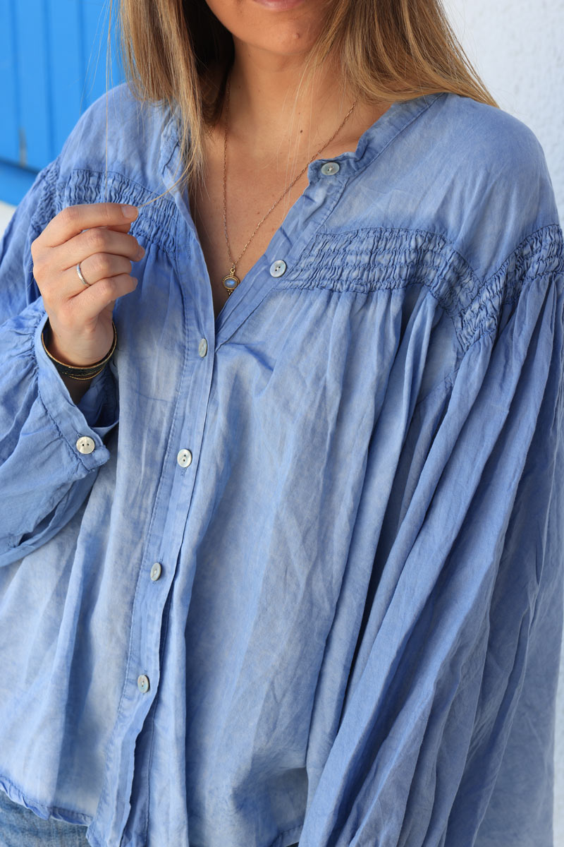 Blusa de algodón denim azul con mangas anchas, botones nacarados y cuello fruncido.