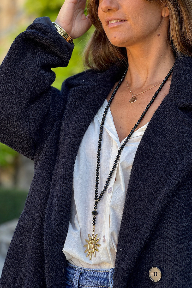 Collier long style sautoir perles facettes noires pendentif soleil doré