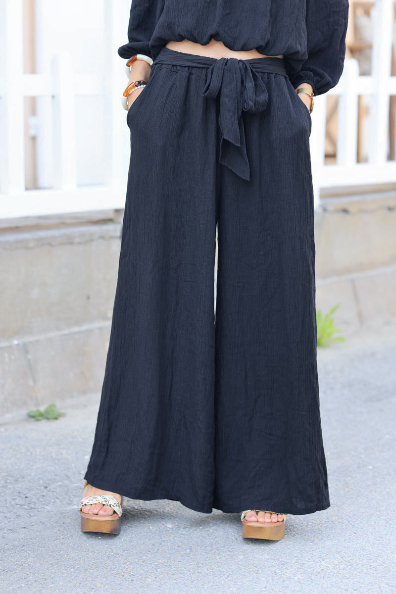 Ensemble pantalon large et fluide noir brillant avec crop top col bardot
