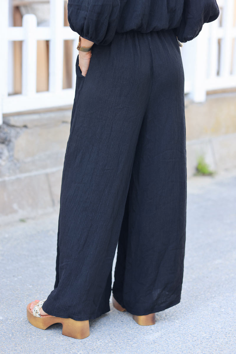 Ensemble pantalon large et fluide noir brillant avec crop top col bardot