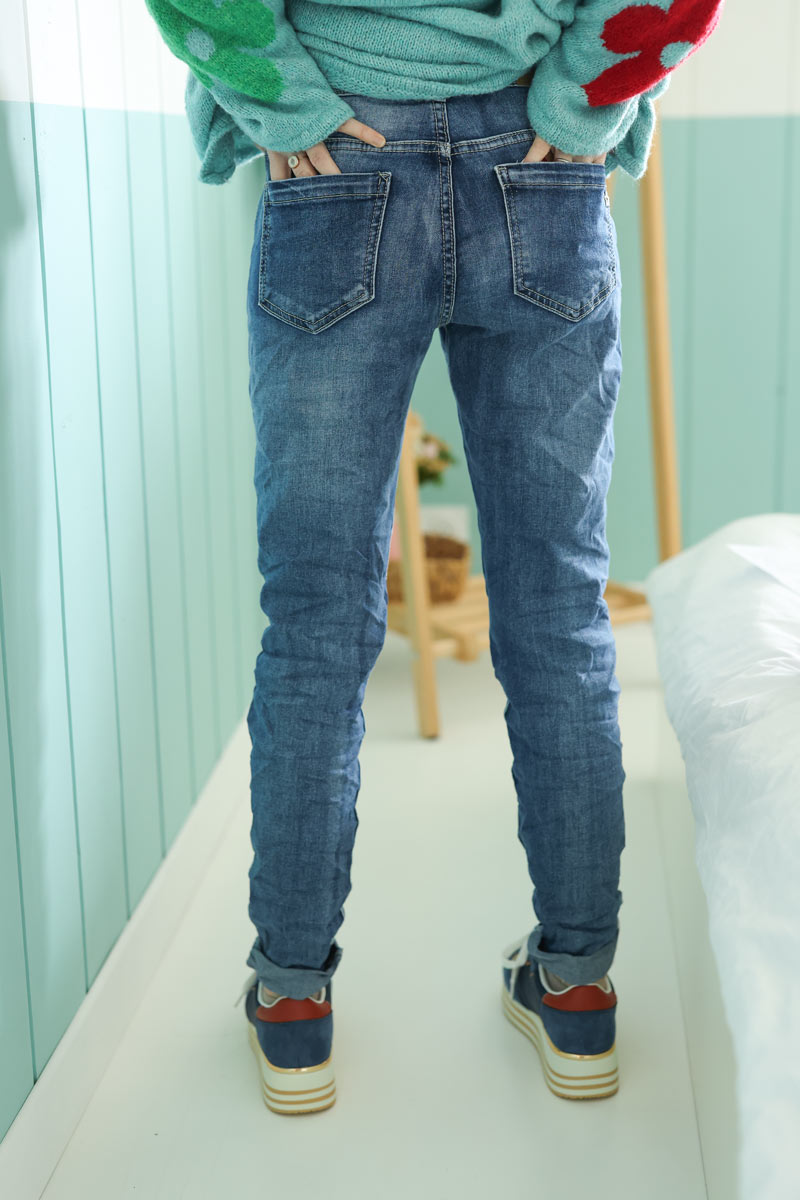 Jeans lavado claro con botones y ribete plateado en los tobillos.