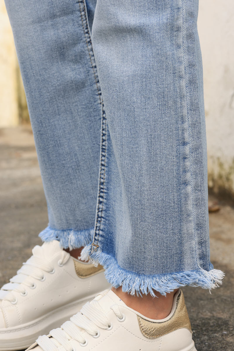 Jeans rectos con lavado claro y acabados con flecos